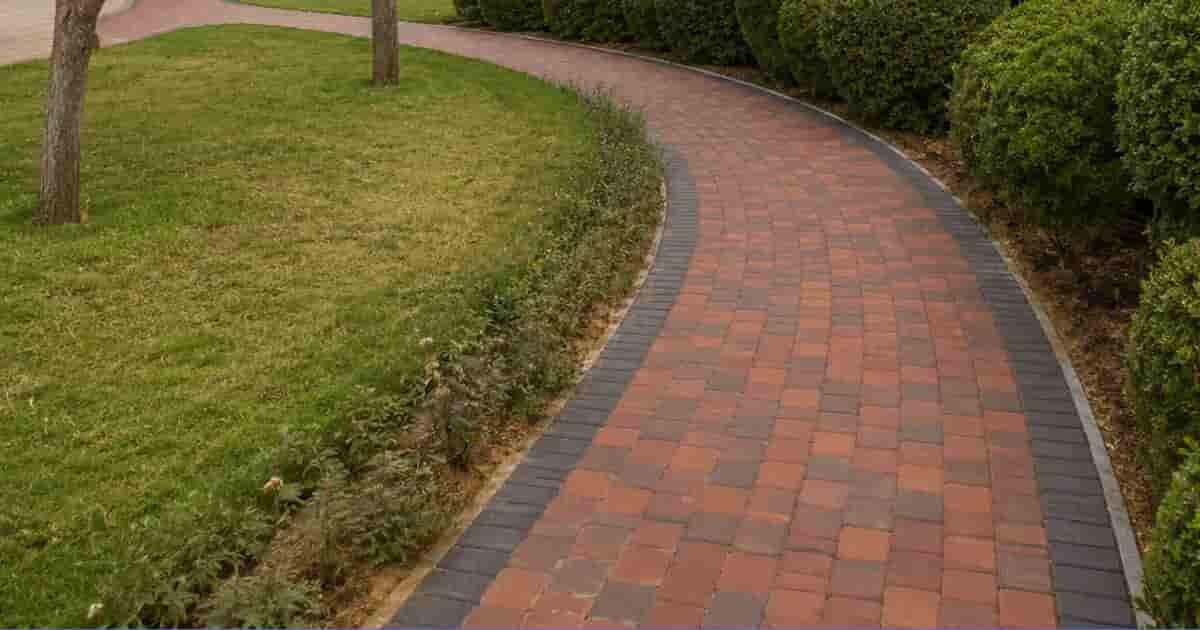 **Alt text:** Curved brick walkway surrounded by rounded green hedges and trees in a Al Mankhool park.