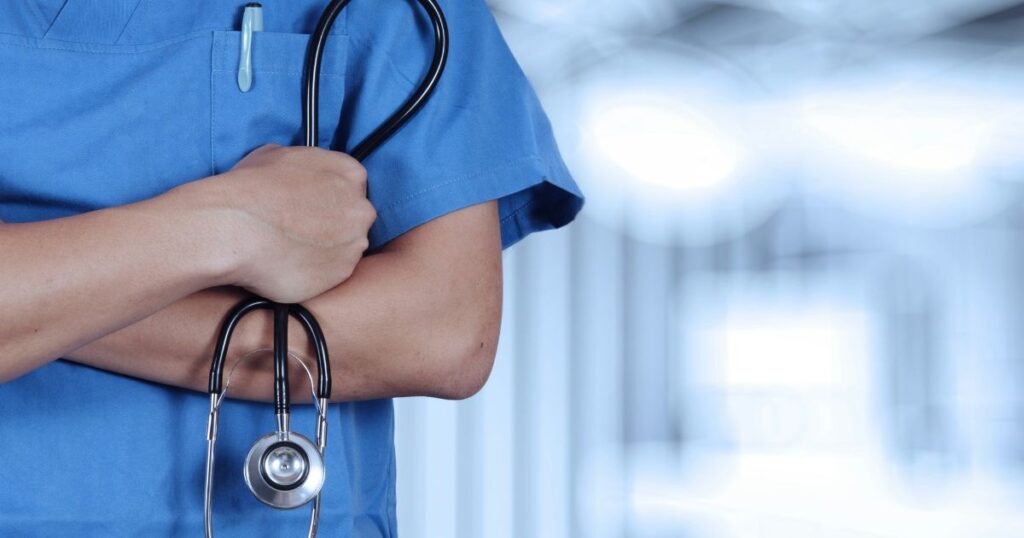 Medical professional holding a stethoscope in a hospital setting