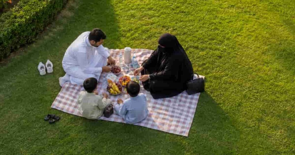 family relaxing and Picnic on a lush green lawn in a peaceful Park